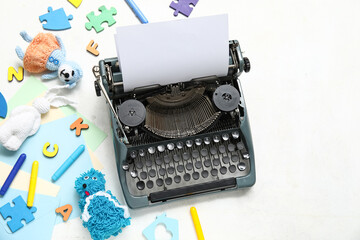 Naklejka premium Composition with vintage typewriter, knitted toys and paper on white background