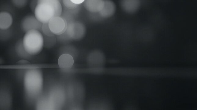 A dark and moody background with blurred lights and a reflective surface