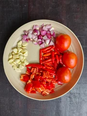 Chopped Fresh Ingredients with Red Chili, Shallots, Garlic, and Tomatoes on a Plate for Indonesian Sambal © Made