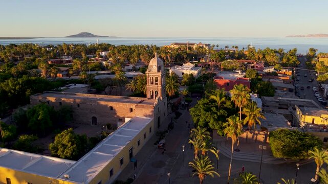 See the sunset at Loreto Mission church in Baja California Sur, Mexico, showcasing the town and desert landscape from above