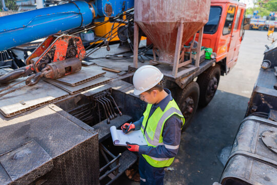 Engineer inspecting truck concrete pump maintenance construction site safety gear
