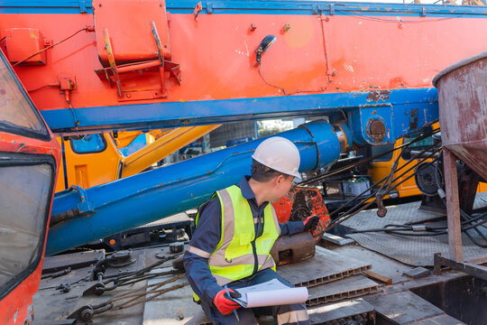 Closeup of engineer inspecting crane mechanism at construction site