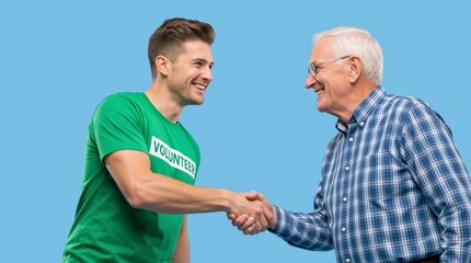 Fototapeta premium Volunteer visiting an elderly person for emotional support. Young man in green shirt shaking hands with senior male. Community service and charity concept on blue background