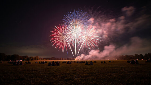 Fourth of July Fireworks Show Over Open Field and Crowd