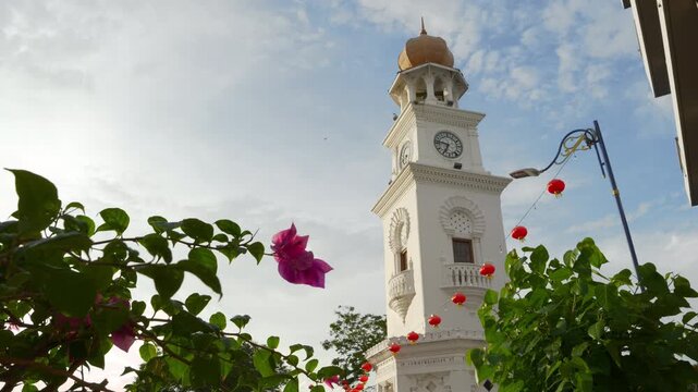 sunny day penang island george town city center famous clock tower front flowers view panorama 4k malaysia