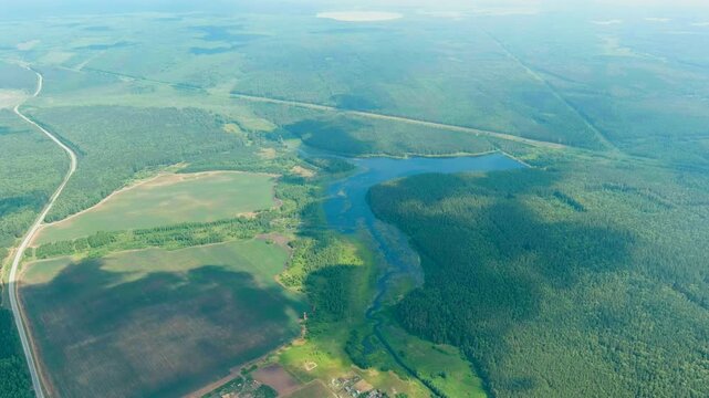 Russia, Ural. Takeoff over fields and forests. Swampy Pond. Clouds with gaps. Drone footage