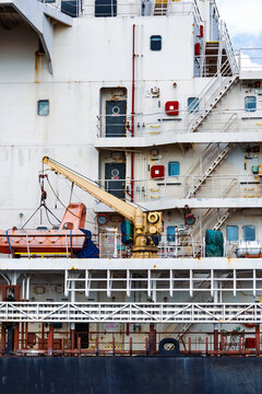 Cargo ship side showing lifeboat and crane