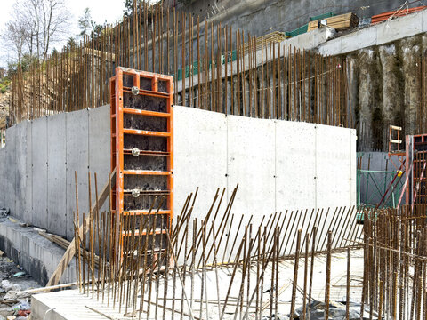 View of concrete walls and vertical steel rebar at a construction site with orange formwork Sariyer, Istanbul, Turkiye.