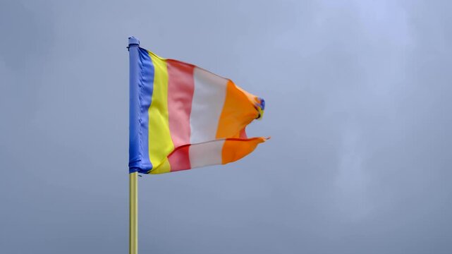 Buddhist rainbow flag flying in windy breeze in Sri Lanka