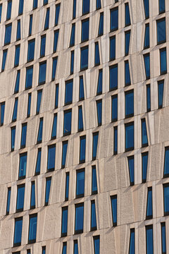 View of the modern architectural facade with geometric window patterns and textured stone panels in Rotterdam, South Holland, Netherlands.