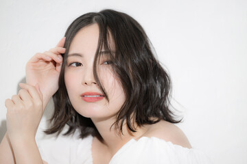 Fototapeta premium アンニュイな表情が魅力的な透明感のある素肌の若い女性のビューティーポートレート ヘアケアや美容など