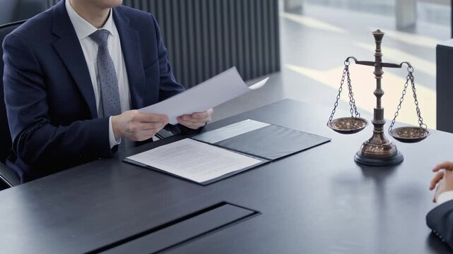 Lawyers or business professionals shaking hands over a legal document with scales of justice, symbolizing agreement, partnership, and resolution in a corporate or legal setting.