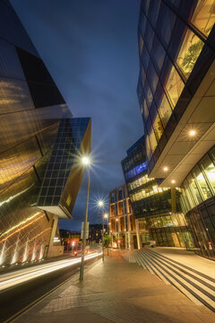 View of the modern architecture at Grand Canal Square featuring the Bord Gais Energy Theatre with illuminated street lamps and light trails at dusk in Dublin, County Dublin, Ireland.