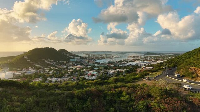 Aerial view of Cole Bay town and Simpson Bay Lagoon on the Dutch side of Saint Martin island in the Caribbean Sea. Drone flight captures the lush green hills and coastal community.