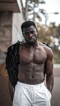 A muscular, dark-skinned man with dreadlocks on his back