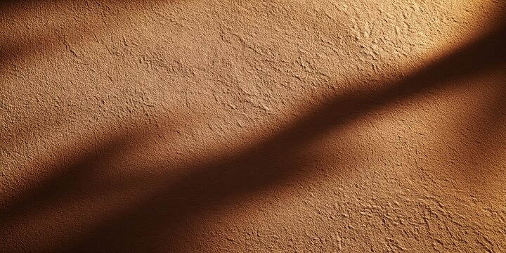 Textured desert wall with dramatic shadow cast at dusk