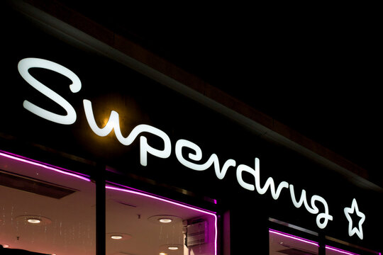 London, UK - December 18 2025: Illustrative editorial close-up of Superdrug illuminated logo sign, representing pharmacy and beauty retail, brand identity, and shopping mall consumer culture