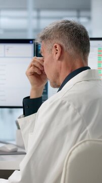 Hospital Administrator Looks Stressed While Reviewing Spreadsheets