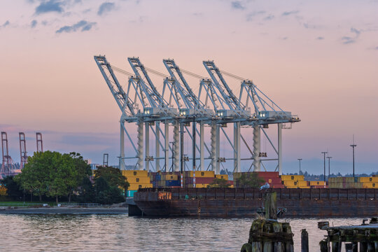 Seattle port SSA terminals with cranes loading containers at sunset
