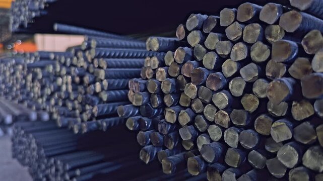 Macro close up shot focusing on the ends of stacked steel rebar in an industrial warehouse
