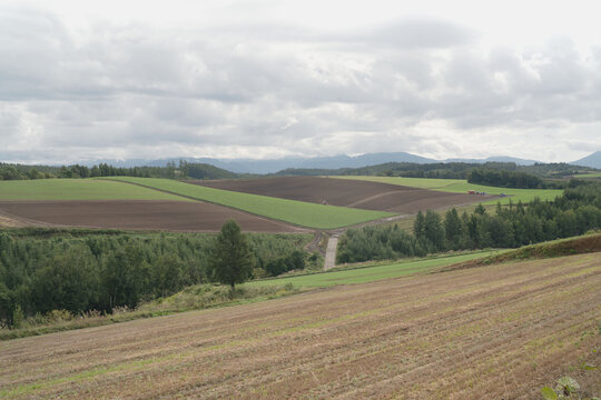 Hokkaido, mountain ridges and woodland, with rural landscape, in september, scene