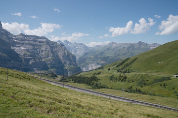Fototapeta premium Switzerland, snowy mountain and mountain ridges, with pasture, in august, scenic view
