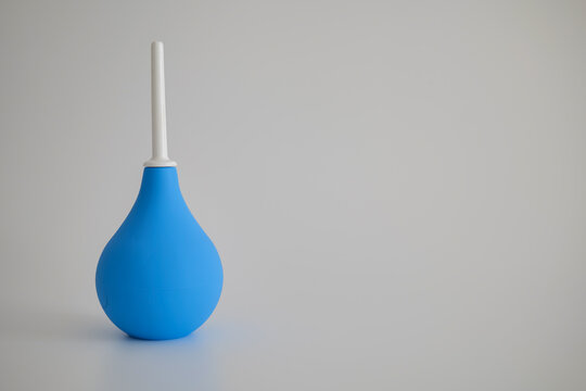 Blue rubber enema bulb syringe isolated on a white background with clear product visibility