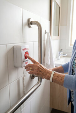 Elderly Woman Pressing Emergency Help Button in Bathroom for Assistance