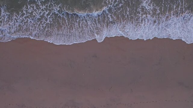 View of beach waves rolling across sandy shoreline creating peaceful coastal landscape scenery