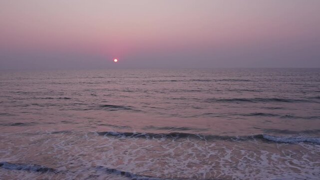 Beautiful view of colorful sunset sky with coastal waves and peaceful seaside atmosphere