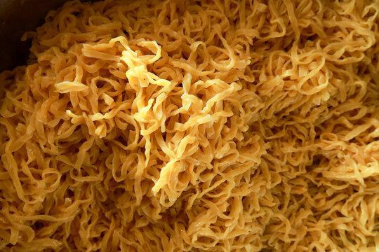 Appetizing close up background showing golden dried shredded squid seafood snack food with chewy stringy texture creating an interesting appealing culinary pattern for asian cuisine lovers