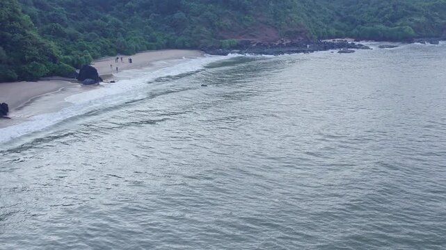 Aerial view of beach waves and hills creating scenic coastal landscape with natural beauty