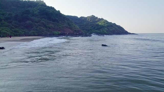 Aerial view of beach waves and hills creating scenic coastal landscape with natural beauty