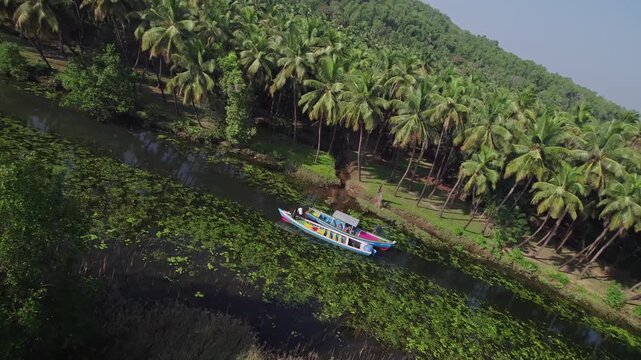 Aerial view of boating in Honnavar backwaters surrounded by palm trees and scenic beauty