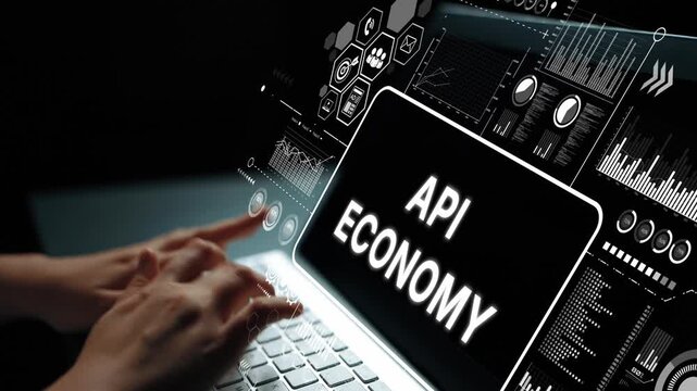 Hands Typing on Laptop with API Economy Concept and Digital Data Visualizations in a Dark Environment. Asymptotic smart data analytic.