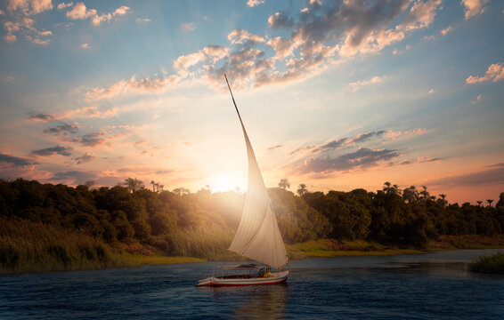 Beautiful Nile scenery with traditional Felluca sailing boat in the Nile - Aswan, Egypt