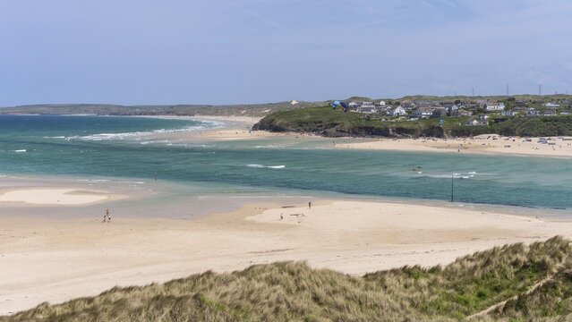 View from Hayle Sands to Hayle Beach and Riviere Towans Beach and some houses. sandy beach beach, sea, kite surfers, landscape, people on the beach. Good weather, blue sky. Hayle Beach, West Cornwall, England, Great Britain