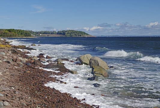 Rocky coast with gentle waves, clear skies and a green coastline, T&ouml;nsberg, Oslofjord, Norway