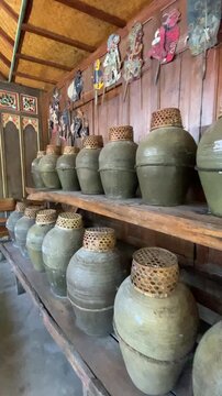 A traditional Balinese arak production area featuring rows of clay jars used for the fermentation and aging process. Concept of traditional distillation, local craftsmanship, and Balinese cultural