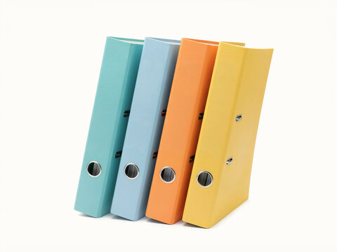 Four Colorful Ring Binder Folders in Pastel Teal, Blue, Orange, and Yellow Standing Leaned Isolated on White Background
