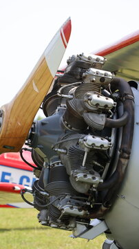 View of a vintage radial aircraft engine with a wooden propeller and metallic cylinders at an airfield in La Ferte-Alais, Ile-de-France, France.