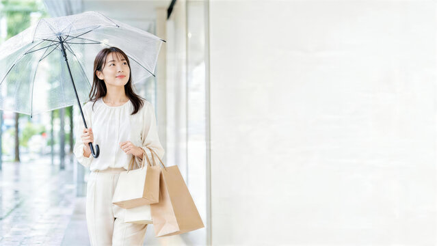 雨の日に透明傘と買い物袋を持つ女性の外出シーン