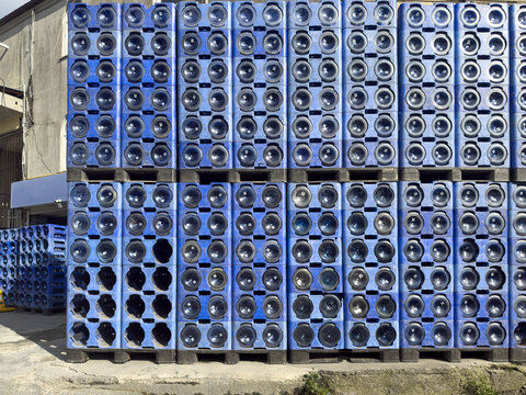 View of stacks of blue plastic crates filled with large water carboys in an outdoor storage area in Sariyer, Istanbul, Turkiye.