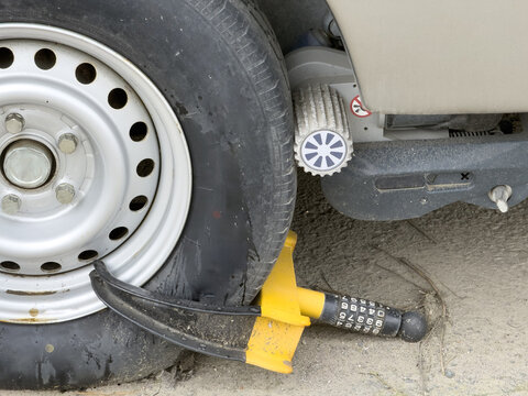 View of a yellow wheel clamp and a motor mover roller engaged on a caravan tire for security and maneuvering in Sariyer, Istanbul, Turkiye.