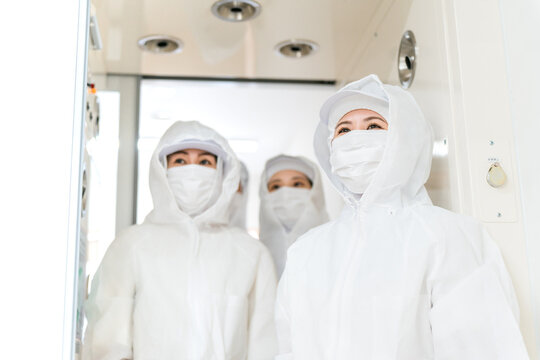 People working in factories with air showers and cleanrooms, staff wearing dustproof suits
