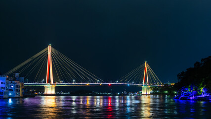 Obraz premium Illuminated Bridge Over Water at Night with Reflections