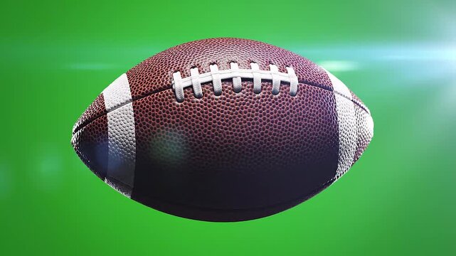 American football in motion against green background.