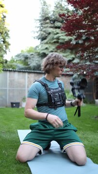 Vertical screen Videographer warms up arms and wrists with camera gimbal before filming preparing muscles for long shooting sessions and repetitive movements