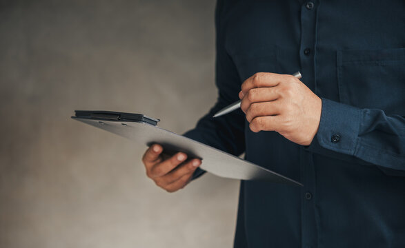 Business Professional Reviewing Procurement Approval Documents on Digital Clipboard for Purchase Authorization, Vendor Evaluation, Compliance Verification and Corporate Decision-Making Process