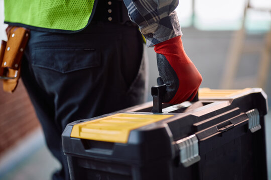 Close up of worker with toolbox at construction site.